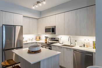 a kitchen with white cabinets and stainless steel appliances at Leena Plantation, Plantation Florida